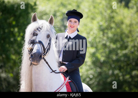 Pure Spanish Horse, Andalusian. Rider in traditional dress on gray stallion on a riding place. Austria Stock Photo