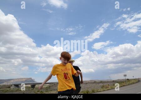 father and son dancing on roadside in Utah USA Stock Photo