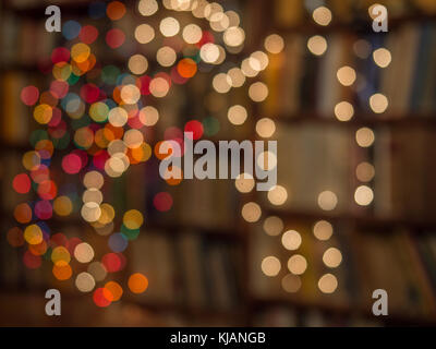 Blurred colorful Christmas lights background over dark background with library. Abstraction. Stock Photo