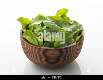 Fresh Green Spinach Leaves in Brown Wooden Bowl Isolated on White Background Stock Photo
