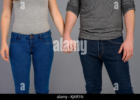 Close up look of the holding hands of a nice young couple Stock Photo