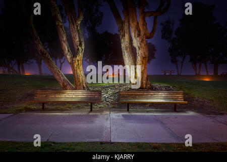 Two Park Benches At Night In City Park Stock Photo