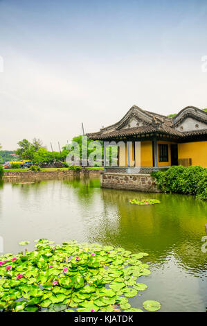 A chinese building on a small lily pond within the Lake Tai or Taihu scenic area on Turtle island in Wuxi China on a sunny day in Jiangsu province. Stock Photo