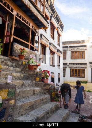 mother and child tourists taking of their shoes Buddhist monastery in Ladakh India Stock Photo