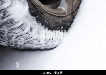 Close up of a cars tires on a snowy road . Stock Photo