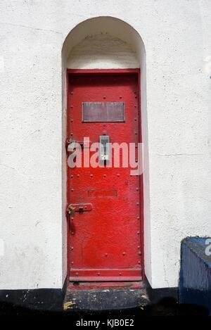 Unusual shaped old  Industrial cast iron door with modern intercom. Stock Photo