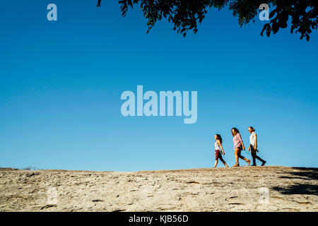 Friends walking under blue sky Stock Photo