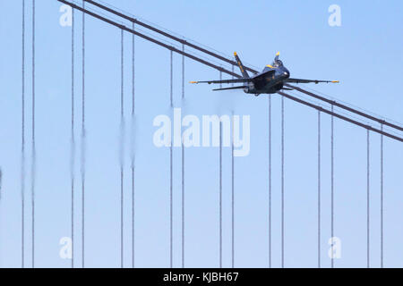 Blue Angels 6, the opposing solo, approached the airshow box from out of the west and over the Golden Gate Bridge Stock Photo