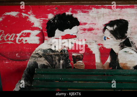 A damaged Coca-Cola advert featuring a couple sharing a drink on a wall in Bangkok, Thailand. Stock Photo