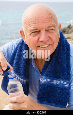 Portrait of Man With Towel Around His Shoulders, Drinking Bottle of Water Stock Photo