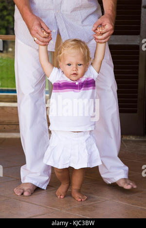 Parent Helping Child to Walk Stock Photo