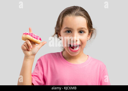 Studio portrait of a beautiful girl with a donut on her finger Stock Photo