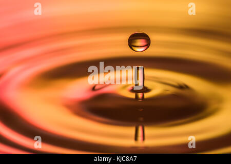 Water drop falling on water surface Stock Photo