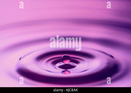 Water drop falling on water surface Stock Photo