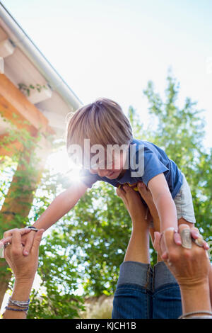 Caucasian boy balancing on feet of mother Stock Photo