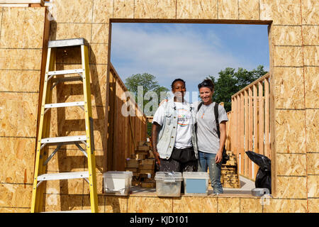 Portrait of volunteers behind window frame at construction site Stock Photo