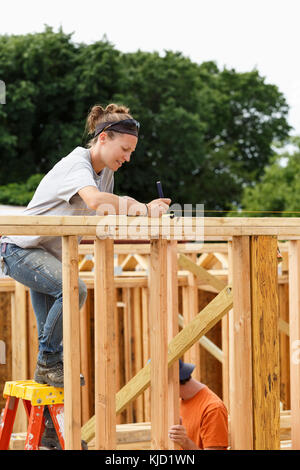 Caucasian woman measuring at construction site Stock Photo