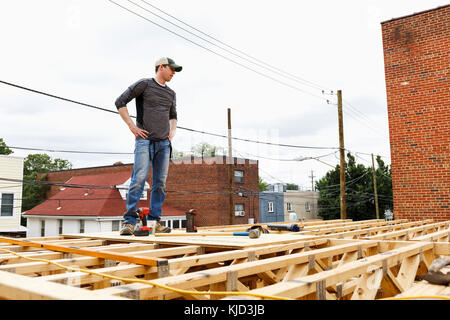 Caucasian man standing on the roof construction site Stock Photo