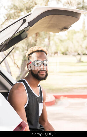 Portrait of Black man wearing sunglasses in car hatchback Stock Photo