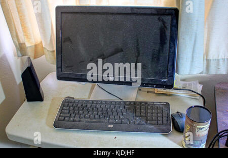 This image shows a dusty computer screen and keyboard, illustrating the accumulation of dust on everyday technology, which is often a common issue in long-term usage of electronic devices. Stock Photo