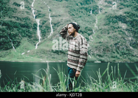 Pensive Caucasian man standing near river Stock Photo