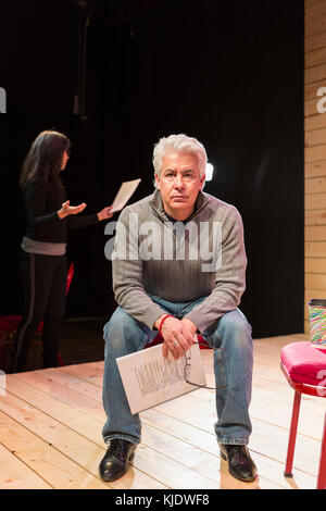 Hispanic man holding script on theater stage Stock Photo