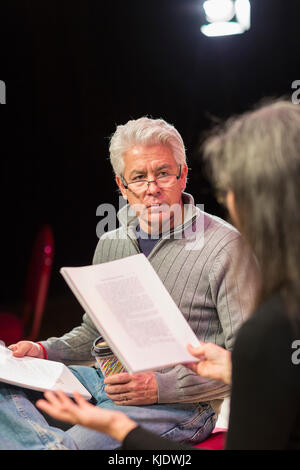 Hispanic man and woman reading scripts in theater Stock Photo