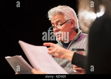 Hispanic man and woman reading scripts in theater Stock Photo