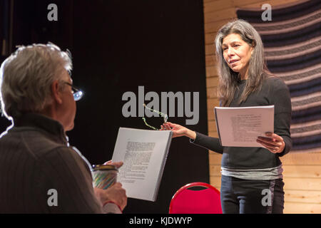 Hispanic man and woman reading scripts on theater stage Stock Photo