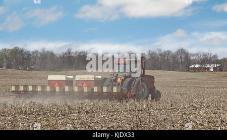 Tractor seeding corn in a farm field Stock Photo