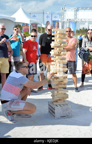 MIAMI, FLORIDA - FEBRUARY 18: Jenga is a game of physical and mental skill created by Leslie Scott, and currently marketed by Parker Brothers, a division of Hasbro. During the game, players take turns removing one block at a time from a tower constructed of 54 blocks seen here people playing at the Sports Illustrated Swimsuit 2016 Swim Beach fan festival Day Two on February 18, 2016 in Miami Beach.  People:  Jenga Stock Photo