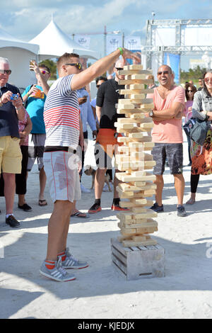 MIAMI, FLORIDA - FEBRUARY 18: Jenga is a game of physical and mental skill created by Leslie Scott, and currently marketed by Parker Brothers, a division of Hasbro. During the game, players take turns removing one block at a time from a tower constructed of 54 blocks seen here people playing at the Sports Illustrated Swimsuit 2016 Swim Beach fan festival Day Two on February 18, 2016 in Miami Beach.  People:  Jenga Stock Photo