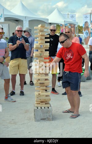 MIAMI, FLORIDA - FEBRUARY 18: Jenga is a game of physical and mental skill created by Leslie Scott, and currently marketed by Parker Brothers, a division of Hasbro. During the game, players take turns removing one block at a time from a tower constructed of 54 blocks seen here people playing at the Sports Illustrated Swimsuit 2016 Swim Beach fan festival Day Two on February 18, 2016 in Miami Beach.  People:  Jenga Stock Photo