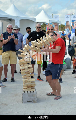 MIAMI, FLORIDA - FEBRUARY 18: Jenga is a game of physical and mental skill created by Leslie Scott, and currently marketed by Parker Brothers, a division of Hasbro. During the game, players take turns removing one block at a time from a tower constructed of 54 blocks seen here people playing at the Sports Illustrated Swimsuit 2016 Swim Beach fan festival Day Two on February 18, 2016 in Miami Beach.  People:  Jenga Stock Photo