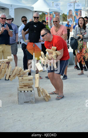 MIAMI, FLORIDA - FEBRUARY 18: Jenga is a game of physical and mental skill created by Leslie Scott, and currently marketed by Parker Brothers, a division of Hasbro. During the game, players take turns removing one block at a time from a tower constructed of 54 blocks seen here people playing at the Sports Illustrated Swimsuit 2016 Swim Beach fan festival Day Two on February 18, 2016 in Miami Beach.  People:  Jenga Stock Photo