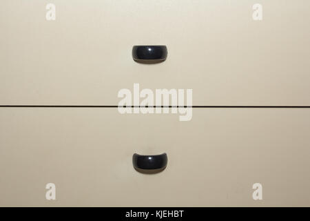 Light coloured cabinet drawers with dark handles, abstract background Stock Photo