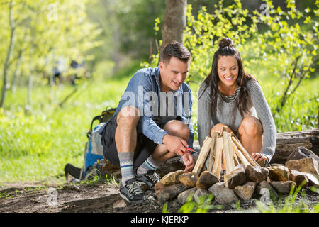 Couple building campfire in the woods Stock Photo