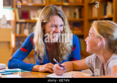 Caucasian teacher helping student in library Stock Photo