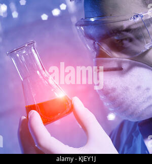 Caucasian scientist examining red liquid Stock Photo