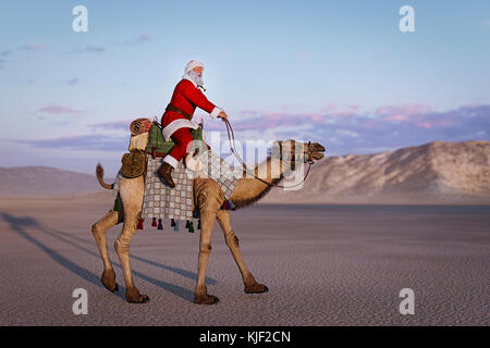 Santa riding camel in desert Stock Photo