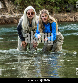 Caucasian mother and daughter fly fishing Stock Photo