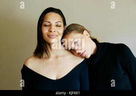 Close up of affectionate mixed race women wearing sweaters Stock Photo