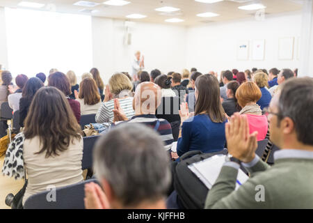 Woman giving interactive motivational speech at entrepreneurship workshop. Stock Photo