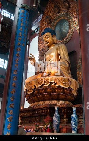 People worshipping a Buddah golden statue at the Jade Buddha temple in Lingyin,Hangzhou，China Stock Photo