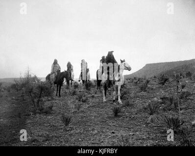 Photograph depicting four Native American men on horseback, in a desert terrain, titled 'Desert Rovers (Apache)', by Edward S Curtis, 1900. From the New York Public Library. Stock Photo