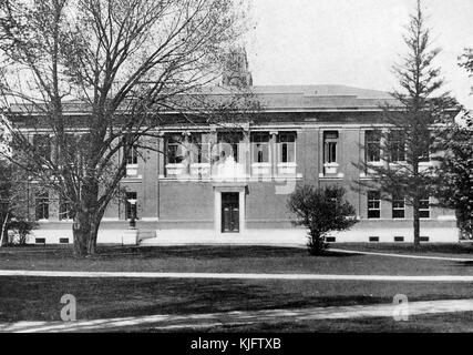 A an external view of Robinson Hall at Harvard University, the large two story building is located on Harvard Yard, it was constructed in the early 20th century and serves as a departmental building among other functions, part of the yard is visible with grass, walkways and trees, Cambridge, Massachusetts, Boston, Massachusetts, 1913. Stock Photo