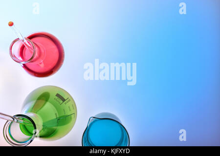 Chemical laboratory glassware with beaker and flasks filled with stirring rod and colored liquid. Top view in perspective Stock Photo