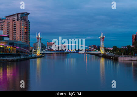 Image of the Lowry Theatres and Lowry Art Gallery take from the Manchester Ship Canal in the early evening with the Millennium Bridge in the background Stock Photo