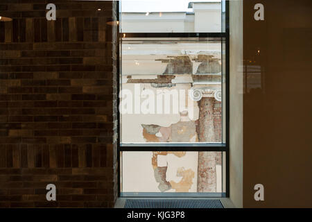 View from window of modern building on dilapidated facade of old building with column and volute. Stock Photo