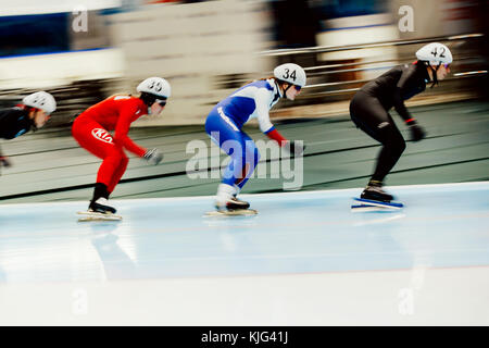blurred motion skaters compete in women mass start during Cup in speed skating Stock Photo
